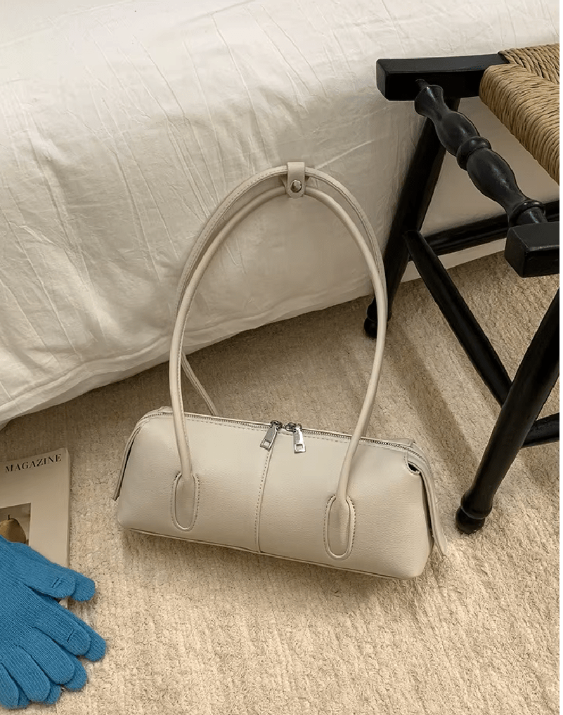 Mira Cylinder Shoulder Bag in cream – styled look